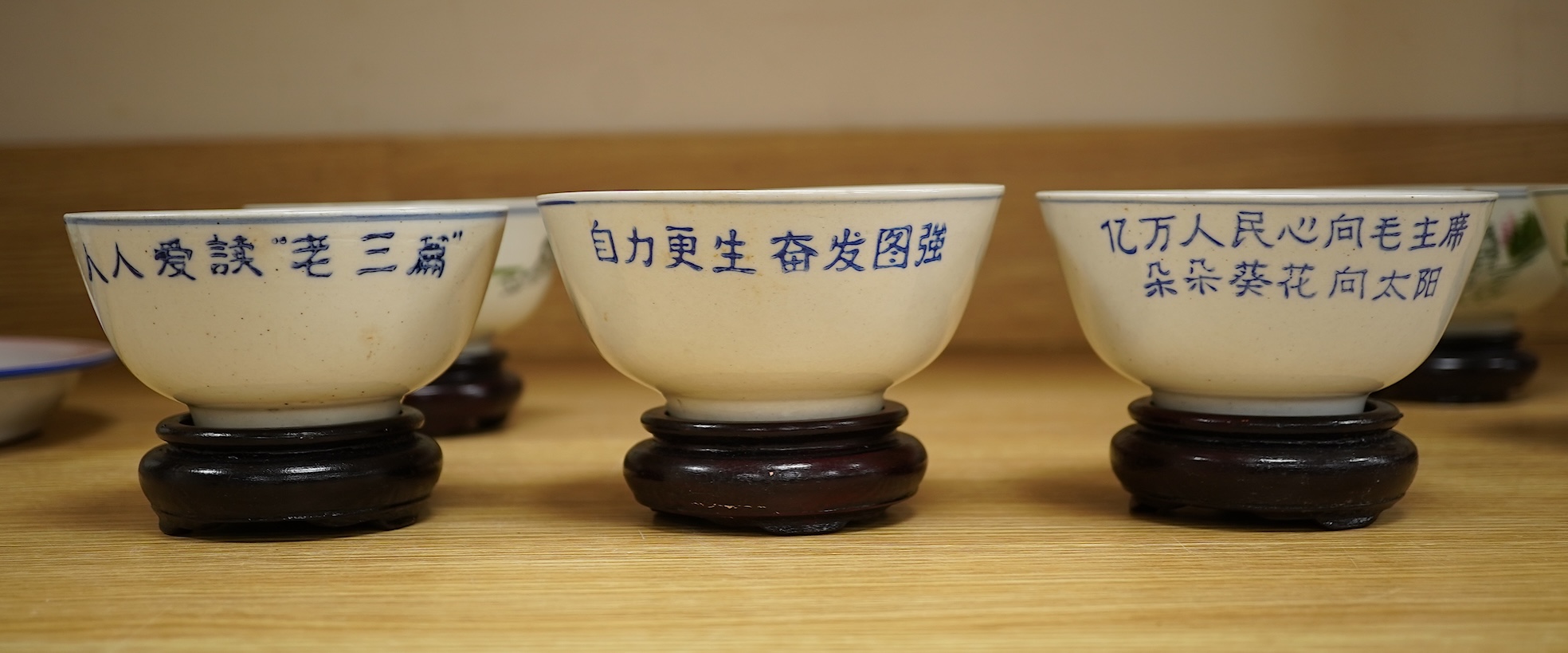A Chinese Cultural Revolution porcelain teapot, six bowls, wood stands and an enamel tray-29.5cm diameter. (8)